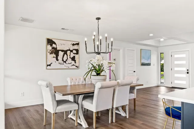 a view of a dining room with furniture wooden floor and chandelier