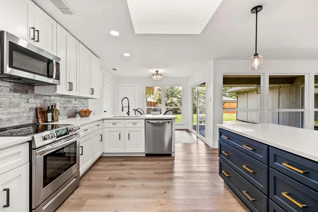 a kitchen with stainless steel appliances granite countertop a stove and cabinets