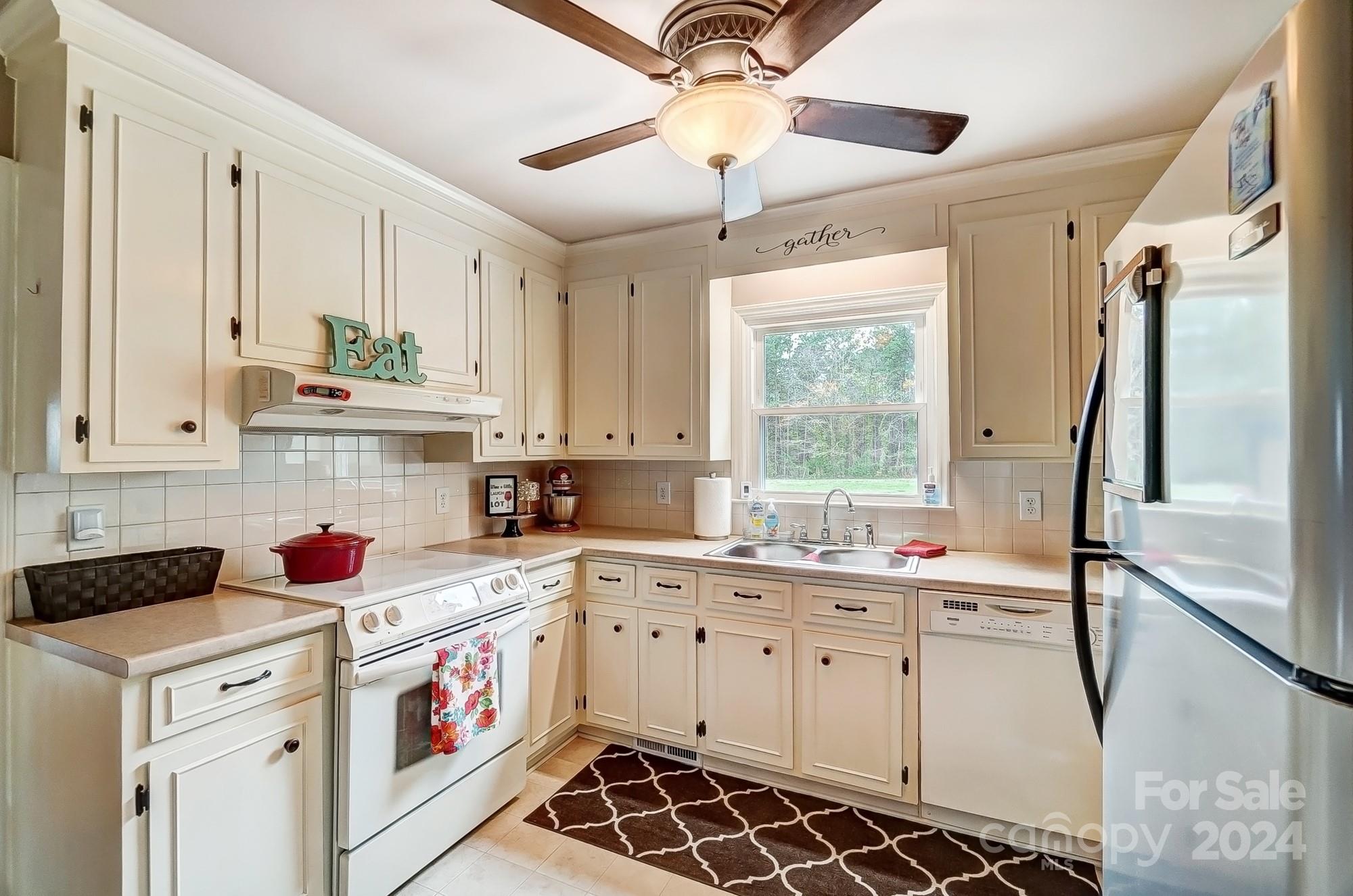 2803 Trinity Church Road Monroe, NC 28112 - Photo 13 of 48 a kitchen that has a lot of white cabinets and a window