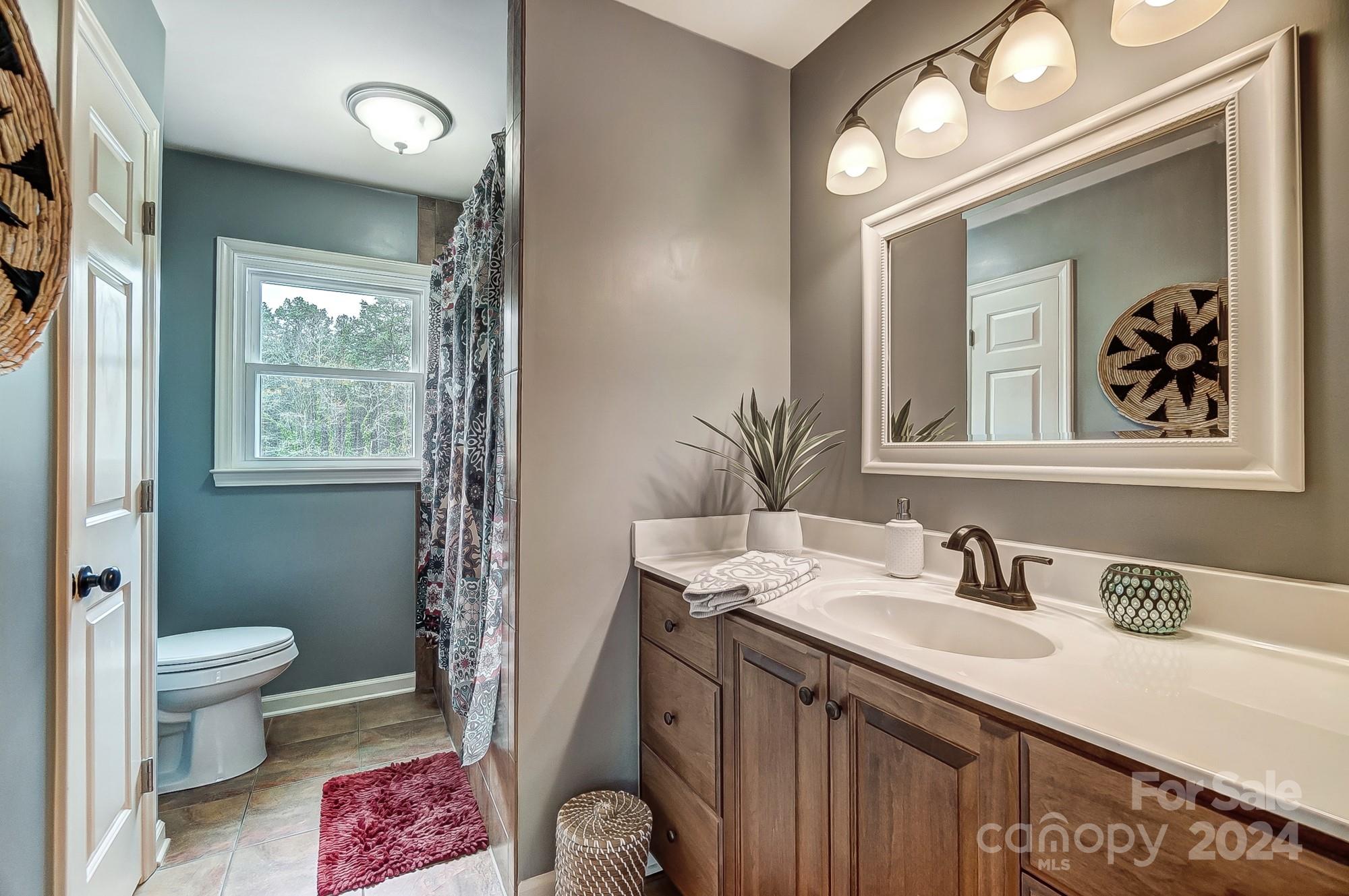 2803 Trinity Church Road Monroe, NC 28112 - Photo 26 of 48 a spacious bathroom with a sink a toilet a shower and a mirror