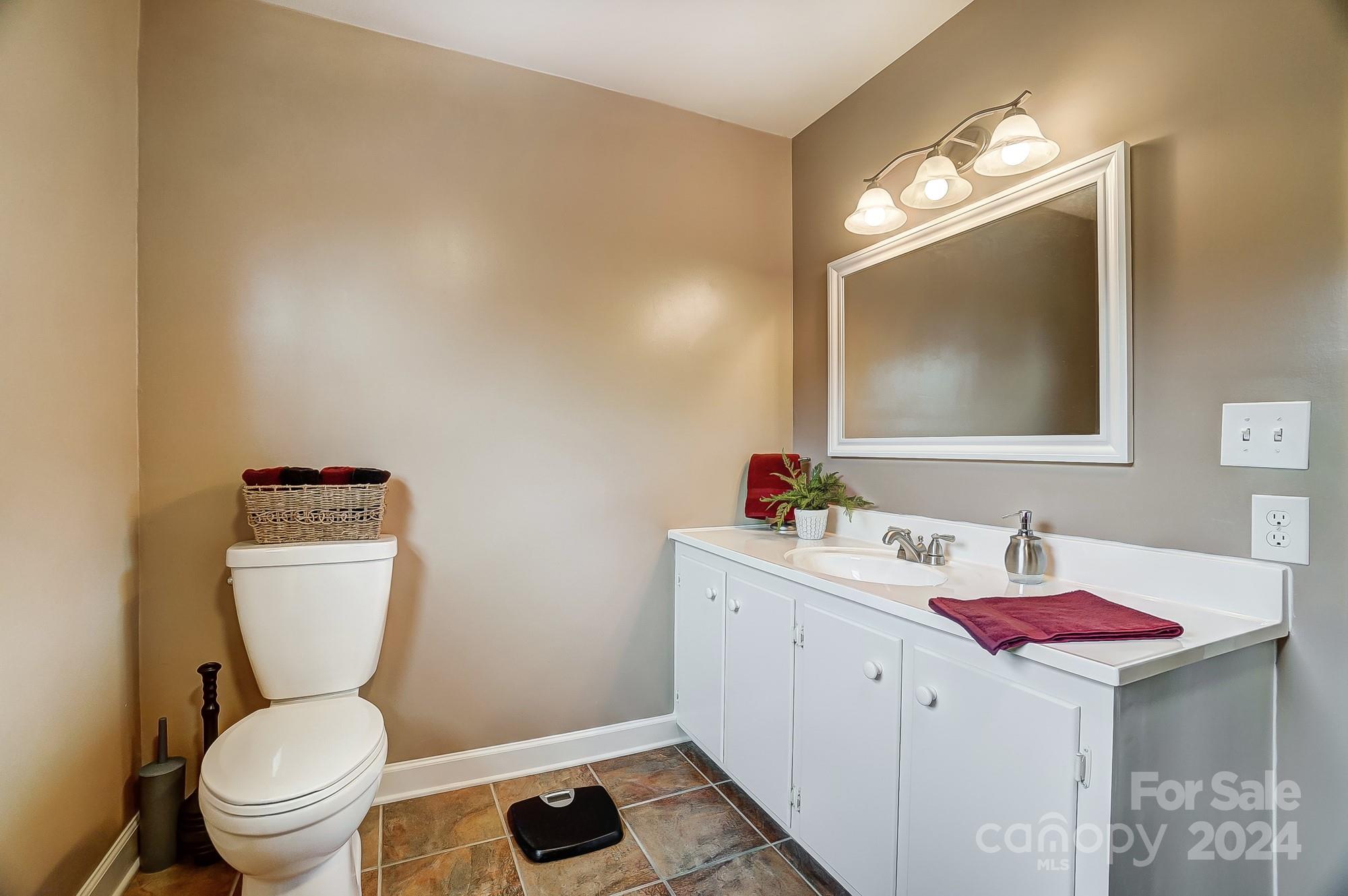 2803 Trinity Church Road Monroe, NC 28112 - Photo 30 of 48 a bathroom with a toilet sink vanity and mirror