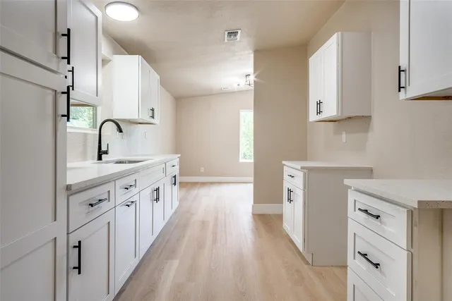 a kitchen with granite countertop a sink stove and cabinets