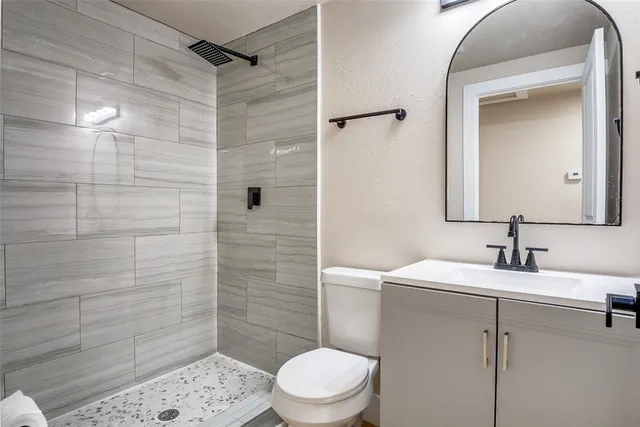 a bathroom with a sink a toilet and shower