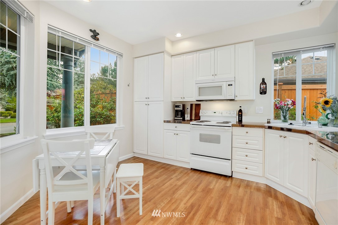 4522 Northeast 6th Court Renton, WA 98059 - Photo 4 of 20 a kitchen with granite countertop white cabinets and white appliances
