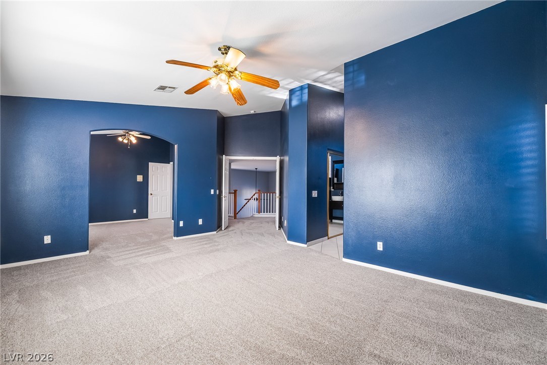 261 Timber Hollow Street Henderson, NV 89012 - Photo 30 of 51 A spacious room offers comfortable carpet flooring and a ceiling fan for year-round comfort.