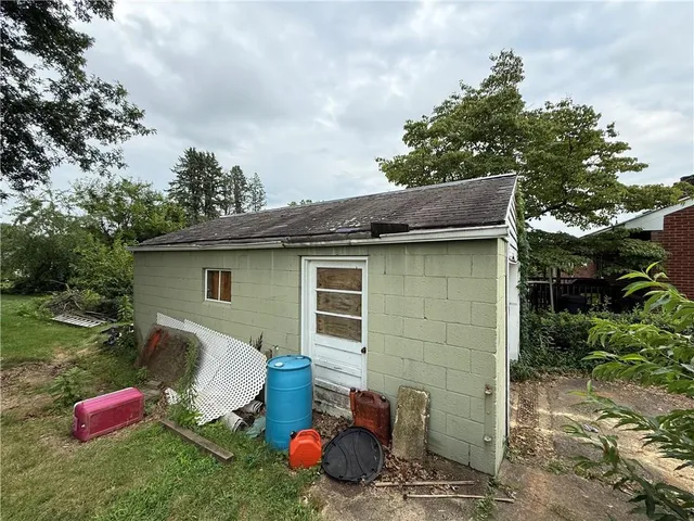 a backyard of a house with table and chairs and a fire pit