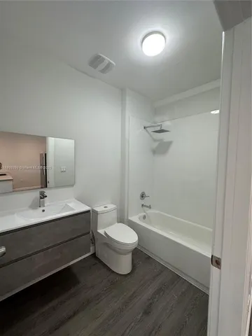 a bathroom with a double vanity sink toilet mirror and bathtub