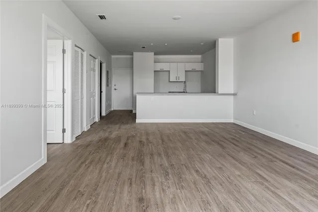 a view of a room with wooden floor and a window