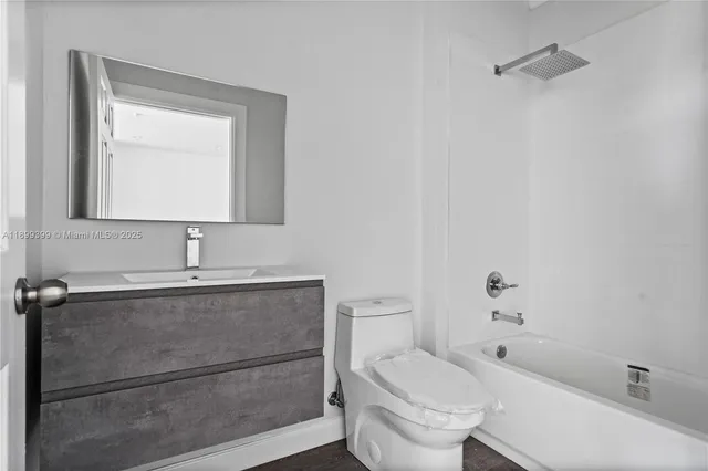 a bathroom with a sink mirror vanity and toilet
