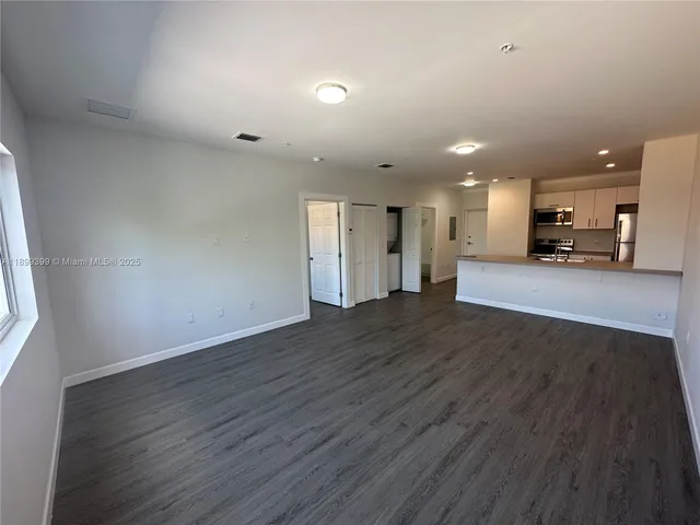 a view of a kitchen with a sink and a refrigerator