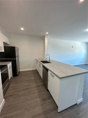 a kitchen with granite countertop a sink and stainless steel appliances