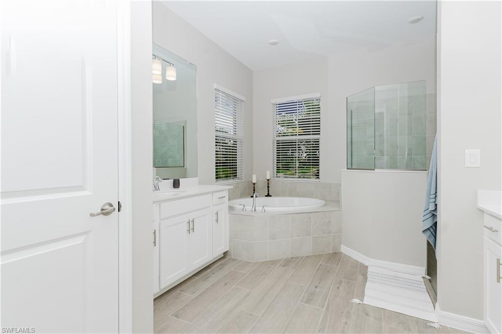 5439 Ternberry Road Ave Maria, FL 34142 - Photo 16 of 50 a spacious bathroom with a bathtub sink and mirror
