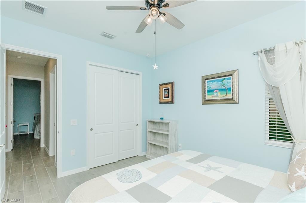 5439 Ternberry Road Ave Maria, FL 34142 - Photo 19 of 50 a bedroom with a bed and a chandelier