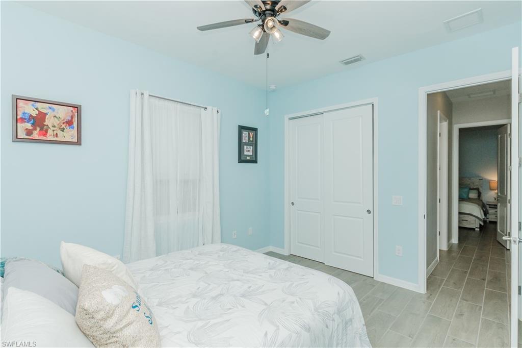 5439 Ternberry Road Ave Maria, FL 34142 - Photo 20 of 50 a bedroom with a bed and a chandelier