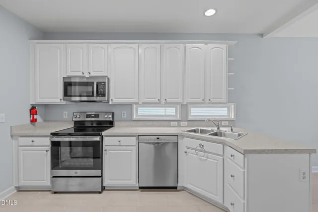 a kitchen with white cabinets and white appliances