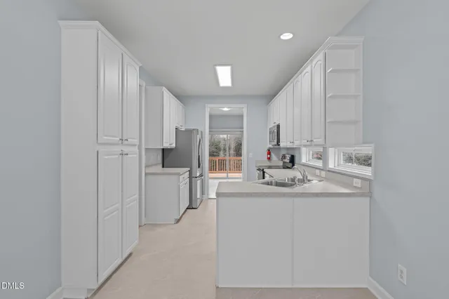 a kitchen with kitchen island white cabinets and refrigerator