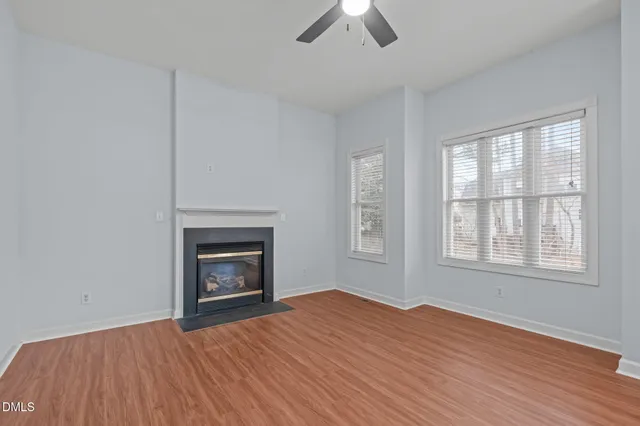 an empty room with windows and fireplace