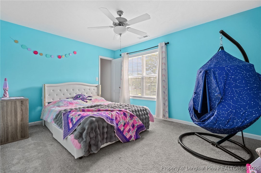 332 Dundee Circle Raeford, NC 28376 - Photo 18 of 35 a bedroom with a bed a chandelier and a dresser