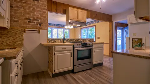 a kitchen with granite countertop white cabinets and white appliances