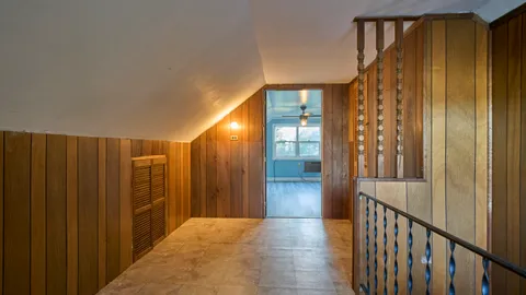 an empty room with wooden floor chandelier fan and windows