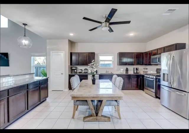 a kitchen with kitchen island a refrigerator stove microwave and cabinets