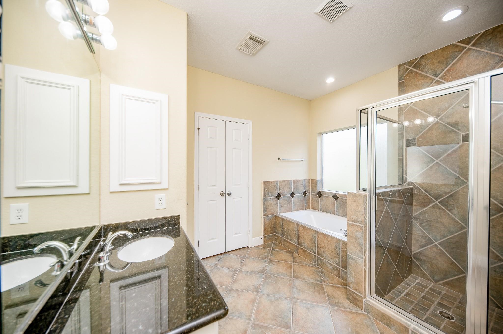 4409 Juan Carlos Court Rosenberg, TX 77471 - Photo 18 of 32 a bathroom with a granite countertop sink a mirror and shower