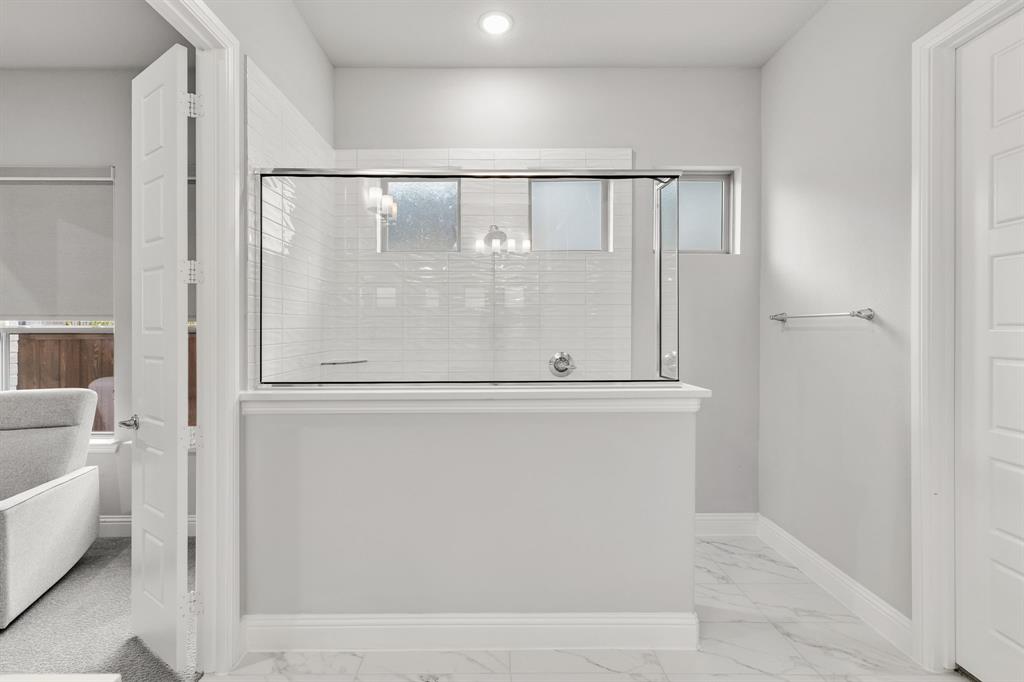 7852 Buffaloberry Road Frisco, TX 75035 - Photo 19 of 36 Walk-in shower with clear glass enclosure and subway tile surround