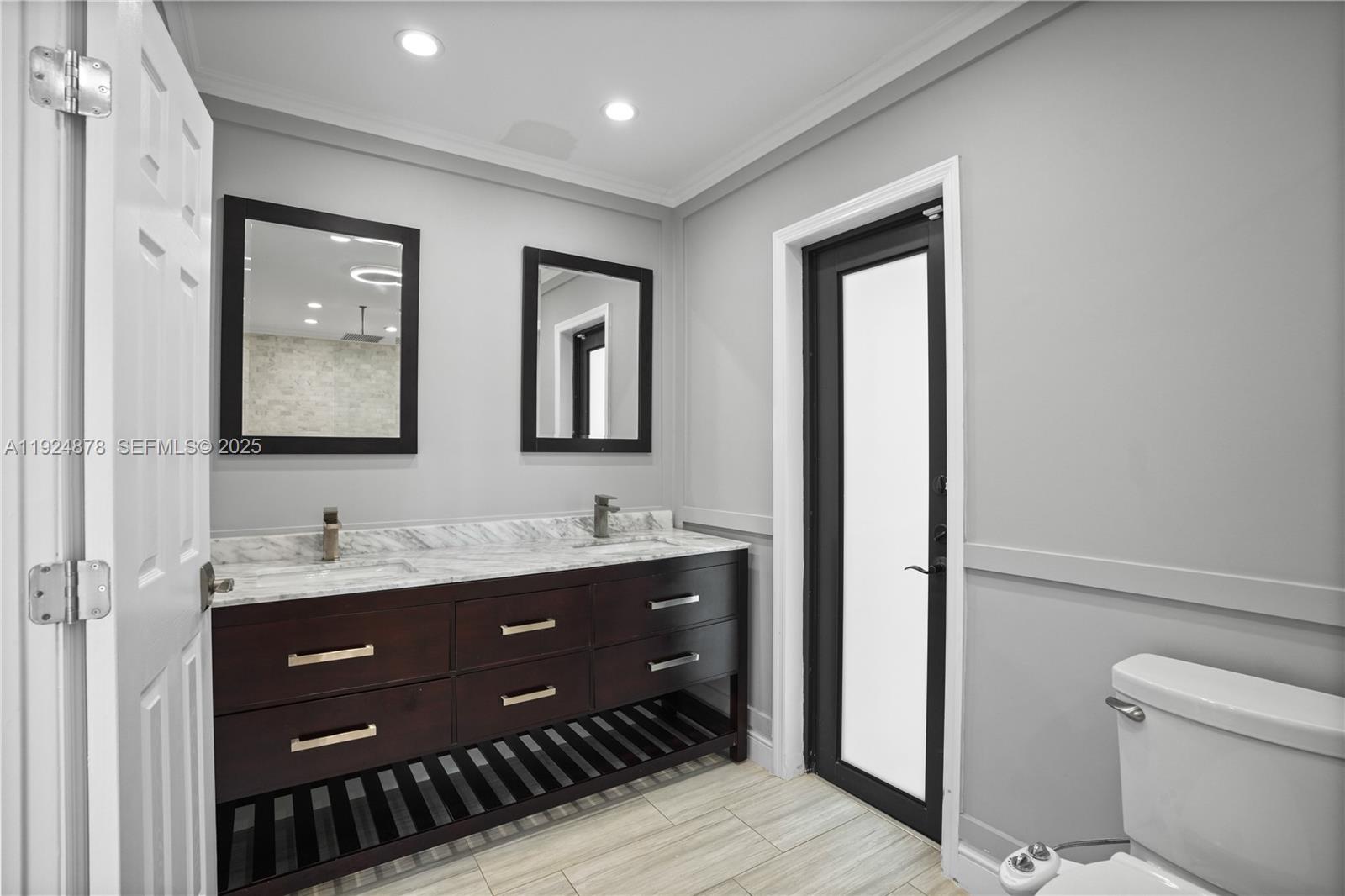 19911 Southwest 82nd Place Cutler Bay, FL 33189 - Photo 18 of 43 a bathroom with a toilet a sink and mirror