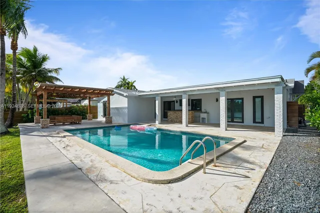 a view of a house with swimming pool and sitting area