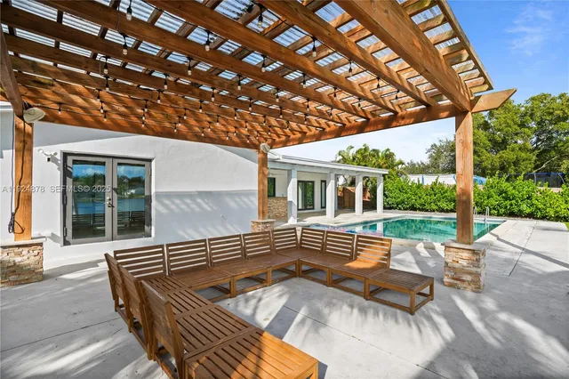 a view of swimming pool with a table and chairs under an umbrella