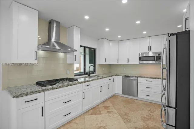 a kitchen with granite countertop a sink stove and refrigerator