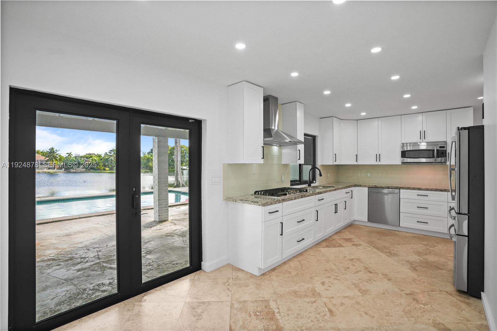 19911 Southwest 82nd Place Cutler Bay, FL 33189 - Photo 7 of 43 a large kitchen with stainless steel appliances granite countertop a stove a sink a refrigerator and white cabinets with wooden floor