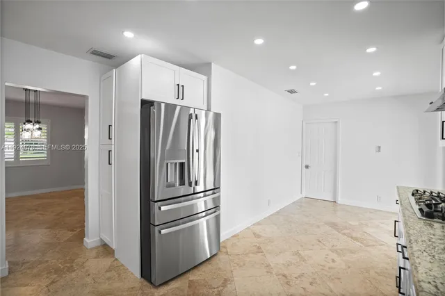 a metallic refrigerator freezer sitting in a kitchen