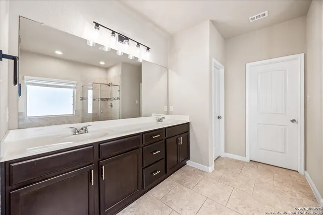 a bathroom with a sink vanity and a mirror