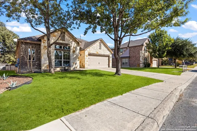 a front view of a house with a yard and trees