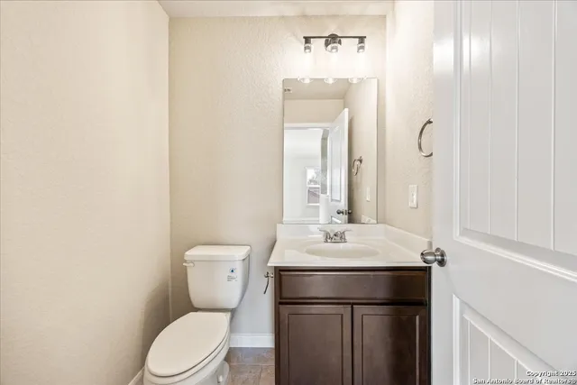 a bathroom with a toilet a sink and mirror