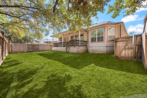 a house that is sitting in the grass with tress in the background