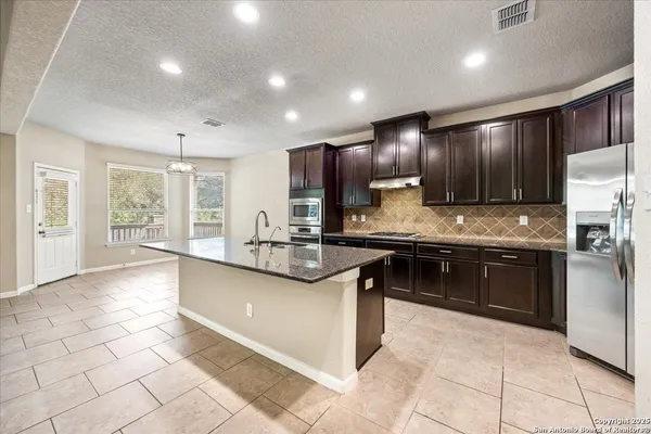 a open kitchen with stainless steel appliances granite countertop a stove sink and cabinets