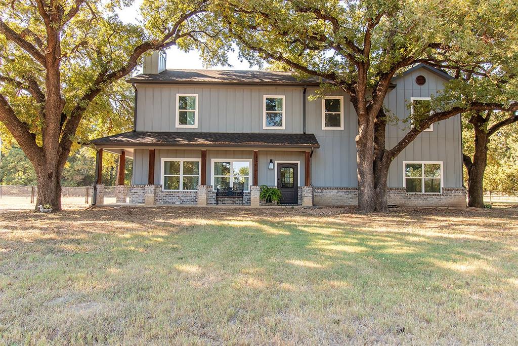 280 Lanier Road Combine, TX 75159 - Photo 1 of 1 View of front facade featuring a porch, board and batten siding, a shingled roof, and brick siding