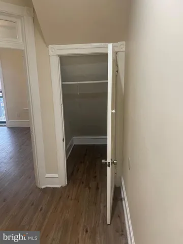a view of a room with wooden floor and a ceiling fan