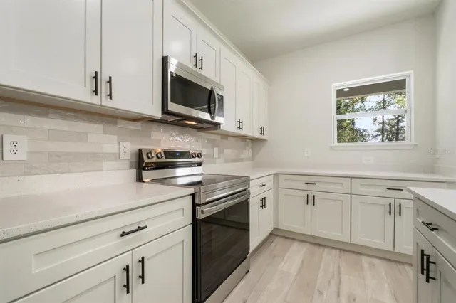 a kitchen with white cabinets stainless steel appliances and sink