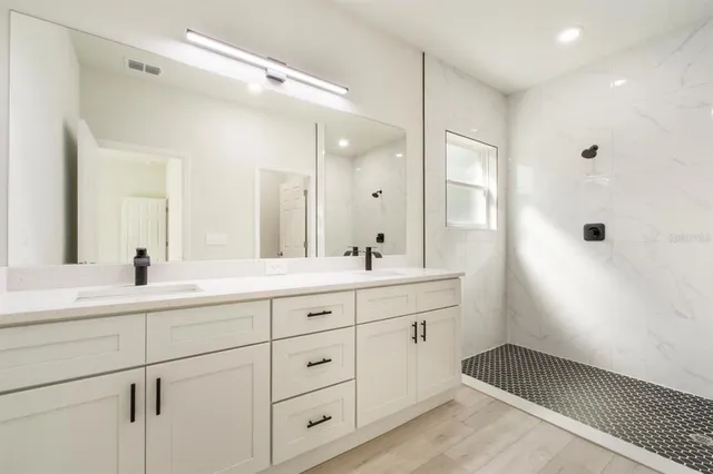 a bathroom with a double vanity sink and mirror with shower