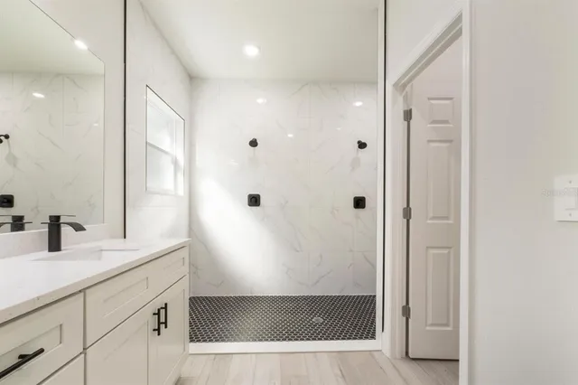 a bathroom with a shower sink and mirror