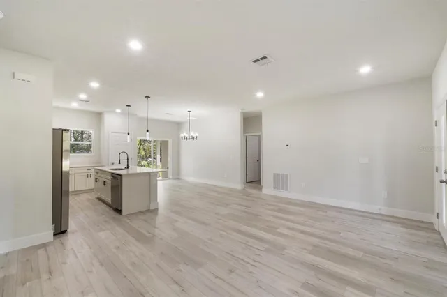 a view of kitchen with refrigerator stove and wooden floor