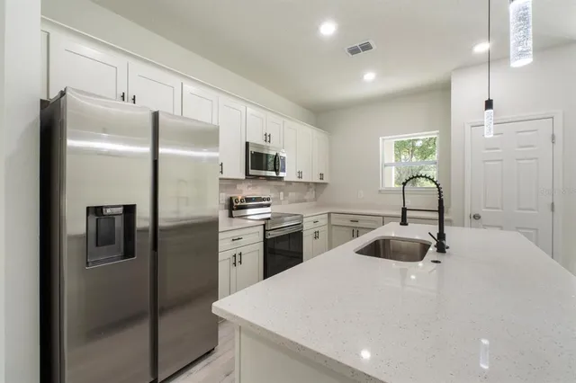 a kitchen with refrigerator a sink and cabinets