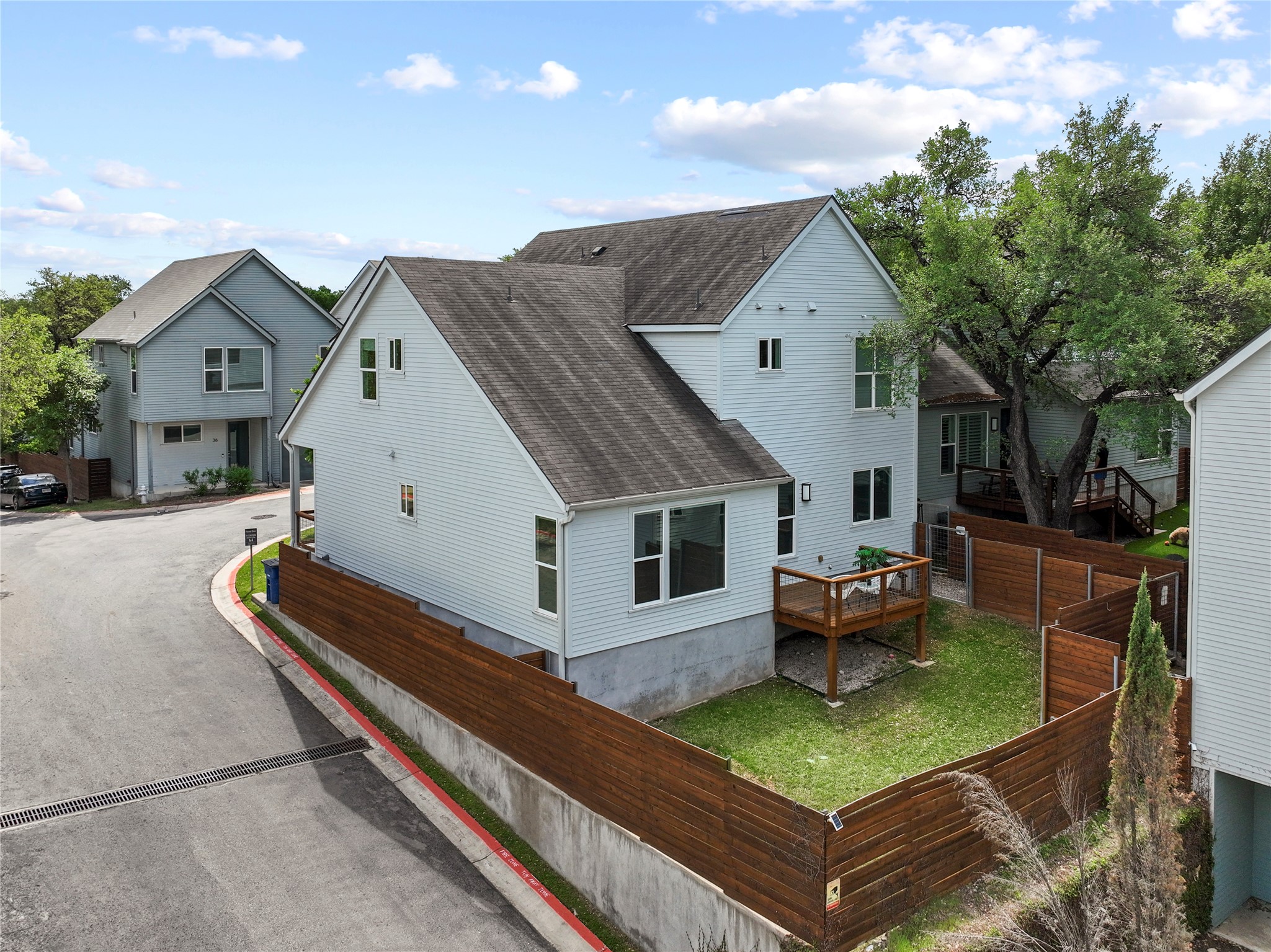 3001 Del Curto Road, Unit 35 Austin, TX 78704 - Photo 22 of 22 The property features light-colored siding, a dark roof, and a private backyard enclosed by a wooden fence