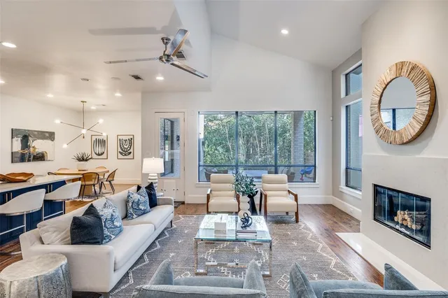 a living room with furniture a fireplace and a large window