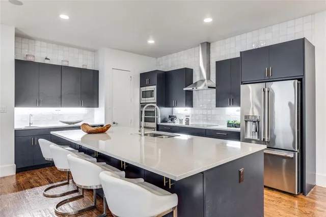 a kitchen with stainless steel appliances a sink and a refrigerator