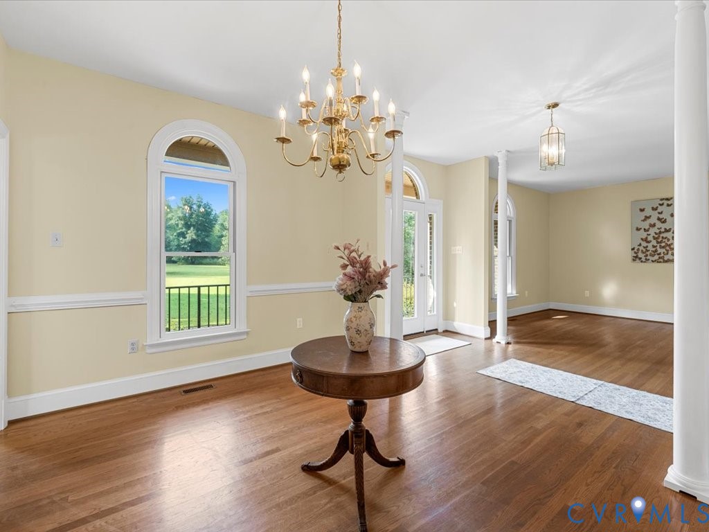 5515 Herring Creek Road Aylett, VA 23009 - Photo 17 of 50 a view of a livingroom with a chandelier wooden floor a chandelier and windows