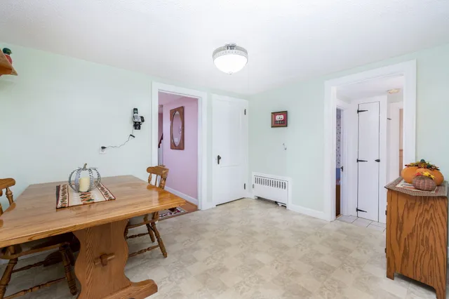 a kitchen with a refrigerator a stove a sink a dining table and chairs